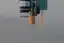 Close render of the head's underside: the microscope, the orange probe arm deployed with its probe wire, and the 200 µL tip