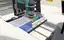 The twin's deck view: the USB microscope and tool head over the printed beaker matrix, with coloured stocks in the back column and the tip rack in front